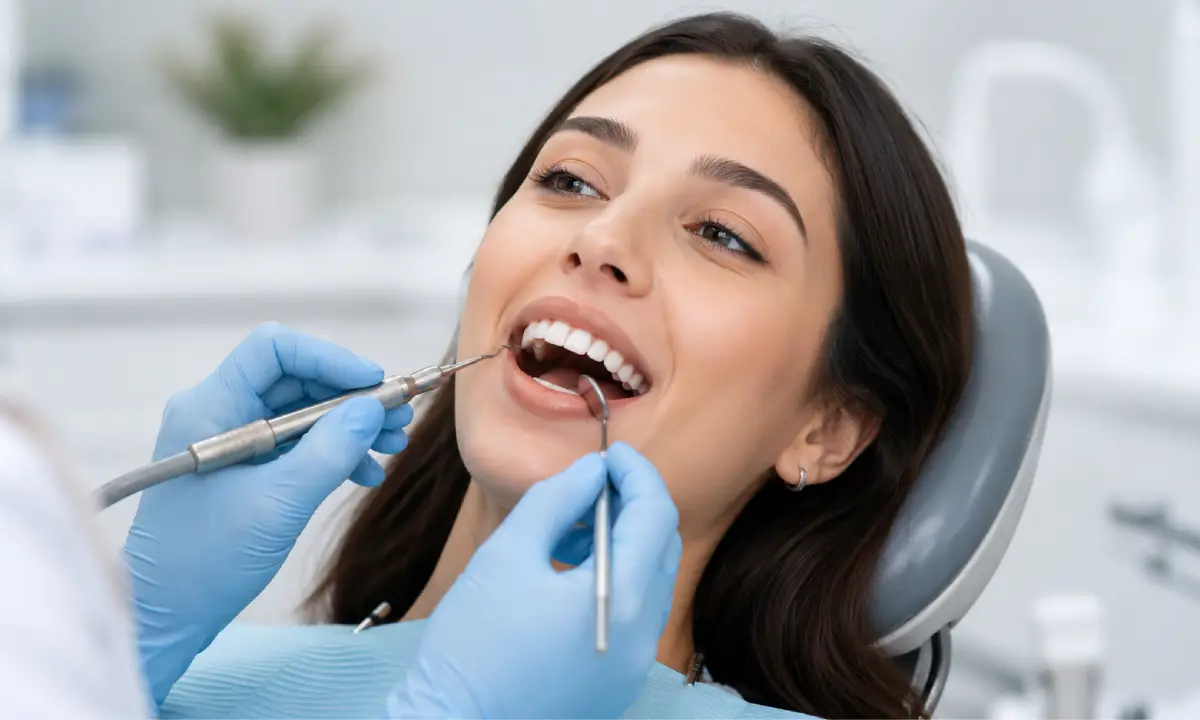 Dentist explaining scaling and root planing procedure to a patient using a dental model